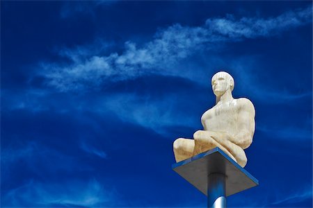 Nice,Provence-Alpes-Cote d'Azur, France. Conversation in Nice Sculpture by Jaume Plensa in Place Massena with clouds and contrails Stock Photo - Rights-Managed, Code: 862-05997645