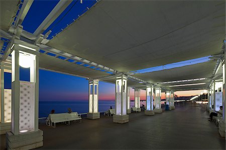 simsearch:862-05997674,k - Saint Philippe, Nice, Provence Alpes Cote d'Azur, France. Canopies over the Promenade Des Anglais with people sitting on benches, Nice at sunset Foto de stock - Con derechos protegidos, Código: 862-05997656