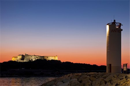 exclusivo - La Fontonne, Antibes, Provence Alpes Côte d'Azur, France. Fort carré, Port Vauban port et le phare d'Antibes à l'avant-plan au coucher du soleil Photographie de stock - Rights-Managed, Code: 862-05997673