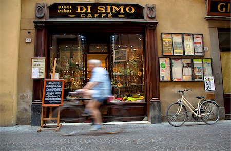 simsearch:862-05997928,k - Italy, Tuscany, Lucca. A person cycling in front of one of the most famous bars in town Stock Photo - Rights-Managed, Code: 862-05997914