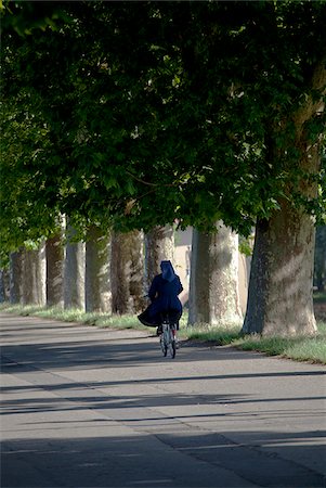 Italy, Tuscany, Lucca. A nun cycling through the street around the fortified city walls Stock Photo - Rights-Managed, Code: 862-05997945