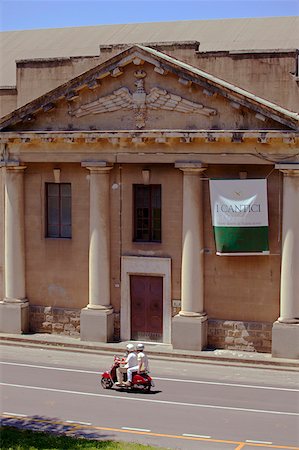 simsearch:862-05997985,k - Italy, Tuscany, Lucca. A stylish 30s building in the historical centre and a couple on a motorino swiftly passing in front Foto de stock - Con derechos protegidos, Código: 862-05997955