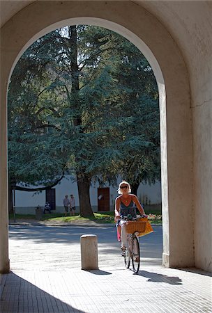 Italy, Tuscany, Lucca. Woman cycling through one of the numerous gates leading to the old city Stock Photo - Rights-Managed, Code: 862-05997957