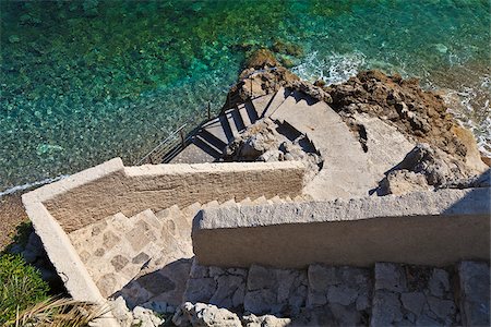 french riviera - Steps down to a small beach near La Condamine, Pointe de la Poudriere, Monaco. Foto de stock - Direito Controlado, Número: 862-05998612