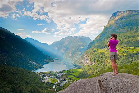 fiordo - Norway, Western Fjords, Geiranger Fjord, Woman taking photograph of Fjord (MR) Fotografie stock - Rights-Managed, Codice: 862-05998753