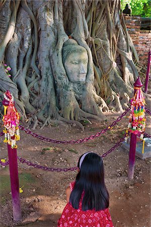 simsearch:862-05999536,k - Thailand, Ayutthaya, Wat Mahathat, Buddha head in tree, Girl Kneeling (MR) Stock Photo - Rights-Managed, Code: 862-05999531