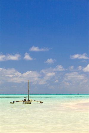 Tanzania, Zanzibar, Unguja, Jambiani. A man sits on his boat. Stock Photo - Rights-Managed, Code: 862-05999577