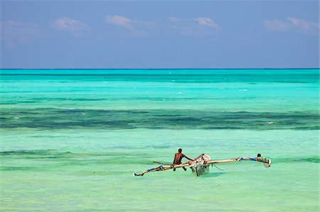 simsearch:851-02963342,k - Tanzania, Zanzibar, Unguja, Jambiani. A man sits on his boat near the shore. Foto de stock - Con derechos protegidos, Código: 862-05999579