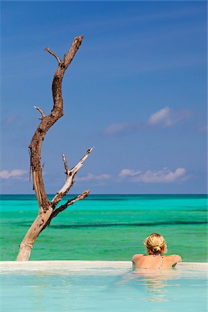 simsearch:862-03737088,k - Tanzania, Zanzibar, Pongwe. A woman relaxes by the pool of the Pongwe Beach Hotel. MR. Foto de stock - Con derechos protegidos, Código: 862-05999585