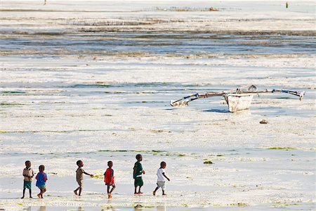 simsearch:851-02963345,k - Tanzania, Zanzibar, Unguja, Jambiani. A group of boys walk along the beach at low tide. Stock Photo - Rights-Managed, Code: 862-05999581