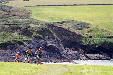 pembrokeshire - Cyclists pushing their bicycles along the coast path, Pembrokeshire, Wales. Fotografie stock - Rights-Managed, Codice: 862-05999686