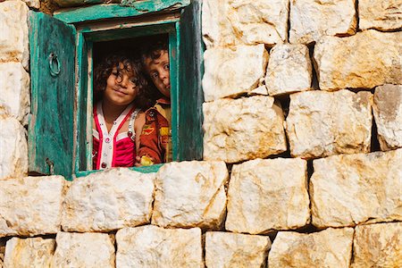 Yemen, Sana'a Province, Haraz Mountains, Al Hajjarah. Children looking through the window of their home. Stock Photo - Rights-Managed, Code: 862-05999726