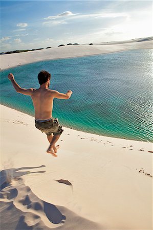 South America, Brazil, Maranhao, a man jumps off a dune into a green lake in the Lencois Maranhenses Stock Photo - Rights-Managed, Code: 862-06540925