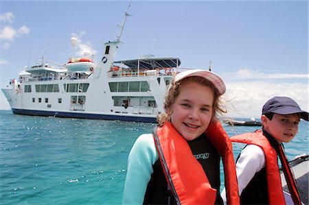 Children on a panga, or zodiac, with expedition ship , Isabela II, in background, Galapagos Islands, Ecuador Stock Photo - Rights-Managed, Code: 862-06541273