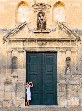 simsearch:862-06541488,k - France, Provence, Arles, Notra Dame de la Major, Woman taking photograph in church doorway. MR Foto de stock - Con derechos protegidos, Código: 862-06541484