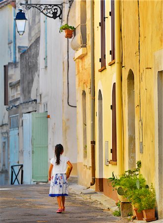 France, Provence, Arles, girl with Baguette walking up alleyway, MR, Photographie de stock - Rights-Managed, Code: 862-06541492