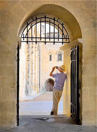 simsearch:862-06541483,k - France, Provence, Avignon, Palais de Papes, Man photographing through archway MR Foto de stock - Direito Controlado, Número: 862-06541506