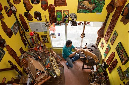 South America, Brazil, Amazonas state, Manaus, sculptor James Alcantara of the stdio J Alcantara Arte em Madeira, carving a wooden jaguar in the family atelier in the Central de Artesanato Branco e Silva Photographie de stock - Rights-Managed, Code: 862-06675699