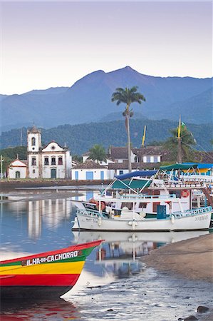 Brazil, Parati, the Portuguese colonial town centre and the church of Saint Rita of Cascia seen from the water with colourful fishing boats moored on the quay Foto de stock - Con derechos protegidos, Código: 862-06675723