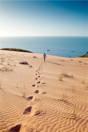 South America, Brazil, Ceara, Morro Branco, a man walks out towards the Atlantic Ocean over the summit of the Morro Branco sand dunes Photographie de stock - Rights-Managed, Code: 862-06675743