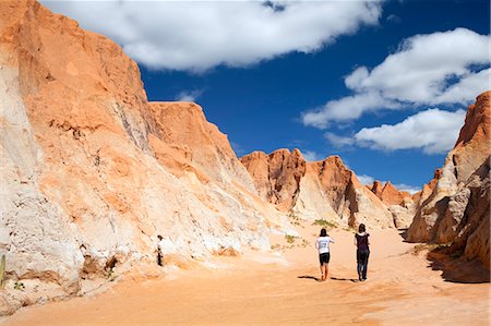 South America, Brazil, Ceara, Morro Branco, a tourist and a guide walk through a canyon in the red sandstone cliffs at Morro Branco Stock Photo - Rights-Managed, Code: 862-06675755