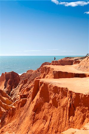 South America, Brazil, Ceara, Morro Branco, a photographer stops to take pictures of the red sandstone cliffs at Morro Branco next to a green Atlantic Photographie de stock - Rights-Managed, Code: 862-06675756