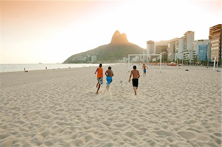 South America, Rio de Janeiro, Rio de Janeiro city, Ipanema, boys playing football on Ipanema beach in front of the Dois Irmaos mountains Stock Photo - Rights-Managed, Code: 862-06675792