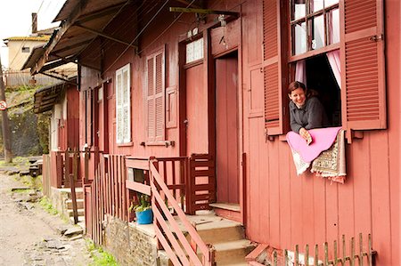 South America, Brazil, Sao Paulo, Santo Andre, Paranapiacaba, a woman looks out of a window in an English built wooden house in the railway village of Paranapiacaba set in the Atlantic Coastal rainforest near on Sao Paulos city limits Stock Photo - Rights-Managed, Code: 862-06676030