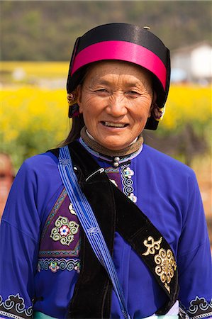 China, Yunnan, Luoping. A lady of the Buyi ethnic minority enjoying the rapeseed blossom at Luoping. Fotografie stock - Rights-Managed, Codice: 862-06676200