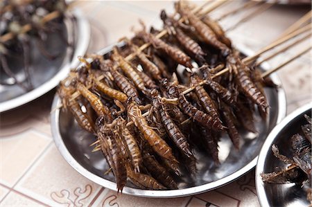 plate of insects - China, Yunnan, Jianshui. Fried earwigs for sale in Jianshui. Photographie de stock - Rights-Managed, Code: 862-06676281