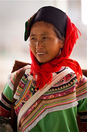 fair people clothing color - China, Yunnan, Xinjie. A lady from the Hani ethnic minority group at Xinjie market, with a woven rush rain protector strapped to her back. Photographie de stock - Rights-Managed, Code: 862-06676297