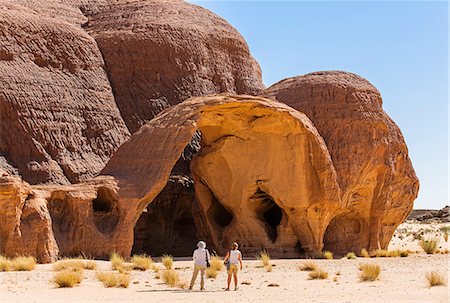 simsearch:862-06676409,k - Chad, Gaora Hallagana, Ennedi, Sahara. Visitors admire the natural beauty of a weathered sandstone rock feature. Stockbilder - Lizenzpflichtiges, Bildnummer: 862-06676406