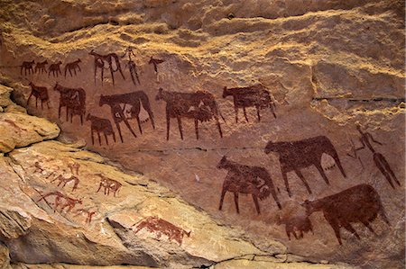 simsearch:851-02963287,k - Chad, Taore Koaole, Ennedi, Sahara. Bichrome paintings of cattle and two human figures decorate the sandstone wall of a cave. Photographie de stock - Rights-Managed, Code: 862-06676442
