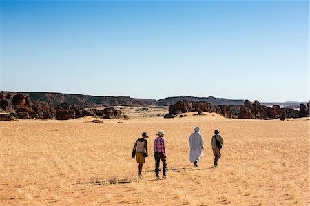 simsearch:862-06676393,k - Chad, Abaike, Ennedi, Sahara. Visitors and a guide walking in the Abaike area. Foto de stock - Con derechos protegidos, Código: 862-06676457