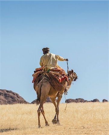 Chad, Bechike, Ennedi, Sahara. A Toubou nomad riding a camel near Bechike. Foto de stock - Con derechos protegidos, Código: 862-06676472