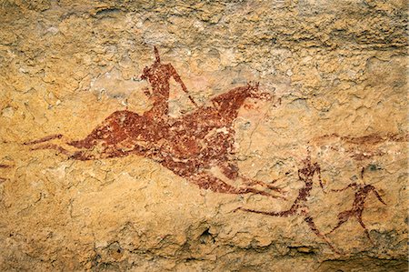 Chad, Terkei East, Ennedi, Sahara. A painting on sandstone of a galloping horse and rider behind two running figures. Foto de stock - Con derechos protegidos, Código: 862-06676484