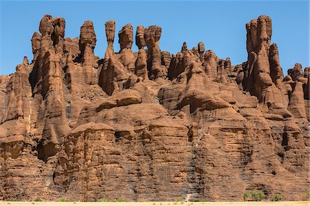 simsearch:862-06676493,k - Chad, Kachabi, Ennedi, Sahara. A striking array of weathered red sandstone columns and pinnacles on a cliff near Kachabi. Fotografie stock - Rights-Managed, Codice: 862-06676480