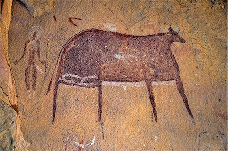 simsearch:862-06676417,k - Chad, Terkei East, Ennedi, Sahara. A large bichrome painting of a cow and a figure holding a lance or stick on the wall of a vast rock shelter. Stock Photo - Rights-Managed, Code: 862-06676491