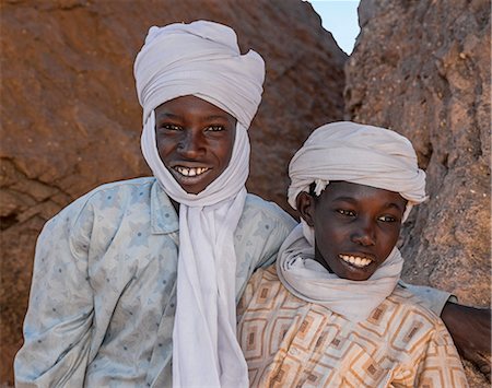 simsearch:862-06676493,k - Chad, Barakatra, Ennedi, Sahara. Two young Tubu boys fresh from riding their horses relax among rocks. Fotografie stock - Rights-Managed, Codice: 862-06676493