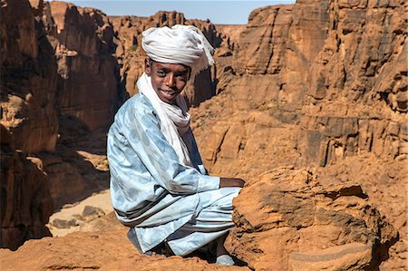 Chad, Wadi Archei, Ennedi, Sahara. A young Toubou boy on a ledge overlooking Wadi Archei. Photographie de stock - Rights-Managed, Code: 862-06676507