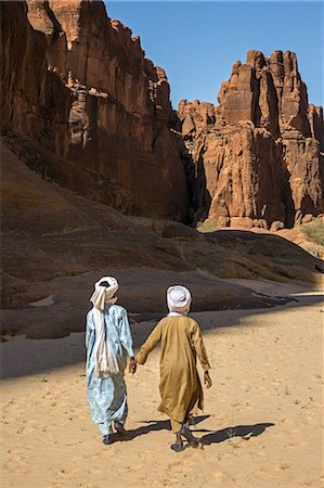 simsearch:862-06676493,k - Chad, Wadi Archei, Ennedi, Sahara. Two young Toubou boys walk along Wadi Archei. Fotografie stock - Rights-Managed, Codice: 862-06676508