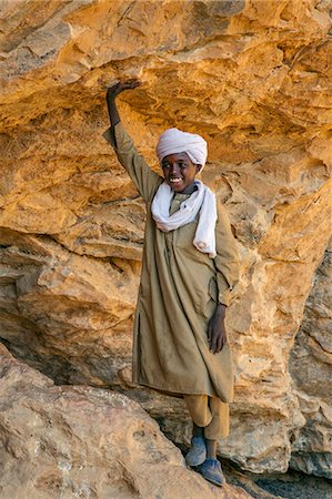 sculpted - Chad, Wadi Archei, Ennedi, Sahara.  A Toubou boy at the entrance to a large sandstone cave. Stock Photo - Rights-Managed, Code: 862-06676525