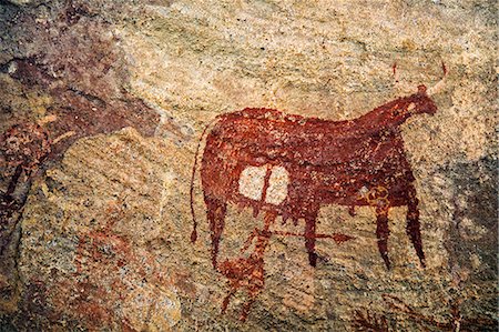 Chad, Terkei West, Ennedi, Sahara.  An ancient rock painting of a human figure with a large spear beneath a Bichrome cow. Stockbilder - Lizenzpflichtiges, Bildnummer: 862-06676530