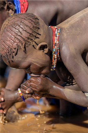etiopia - A young Dassanech girl drinking dirty water from the Omo River, Ethiopia Foto de stock - Con derechos protegidos, Código: 862-06676726