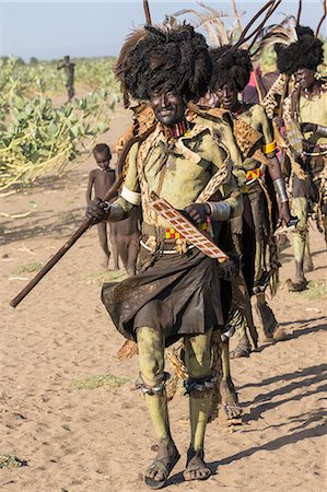 Dassanech men dressed in ceremonial Dimi regalia march in single file to dance, Ethiopia Foto de stock - Con derechos protegidos, Código: 862-06676734