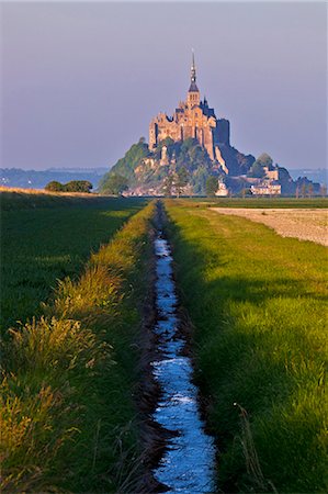 Mont Saint Michel  at sunset viewed from a polder and a drainage channel, Le Mont Saint Michel, Basse Normandie, France. Fotografie stock - Rights-Managed, Codice: 862-06676794