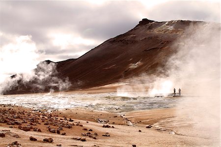 Tourists viewing the boiling mud pits, fumaroles and sulphur-stained deposits at Hverarond beneath Namafjall mountain, near Lake Myvatn in northern Iceland Stockbilder - Lizenzpflichtiges, Bildnummer: 862-06676801