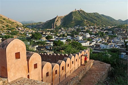 India, Rajasthan, Jaipur, Amber. A village woman carries fodder gathered by the crenellated walls surrounding Amber Fort. Photographie de stock - Rights-Managed, Code: 862-06676848