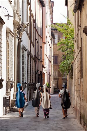 Italy, Lucca. Four cellists walking home through the narrow streets of Lucca after their lesson. Photographie de stock - Rights-Managed, Code: 862-06676877