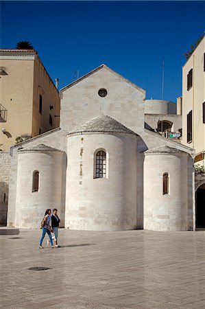 simsearch:862-06676885,k - Italy, Campania, Bari. Two young woman walking in front of a Romanesque church. Stockbilder - Lizenzpflichtiges, Bildnummer: 862-06677039